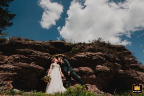 French Alps wedding: A newlywed couple kissing  on a scenic mountain summit in the Vosges.